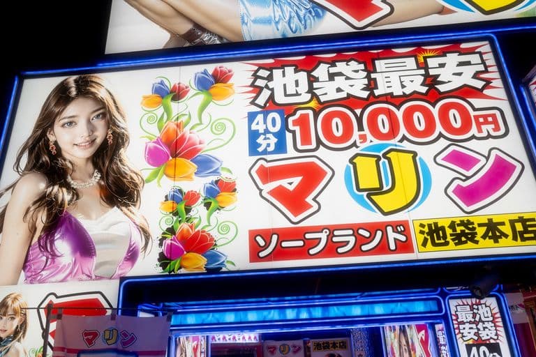 Brightly lit Japanese sign advertising a 40-minute massage service for 10,000 yen at a location in Ikebukuro, featuring a woman with long brown hair in a purple and white dress and colorful flowers next to her.