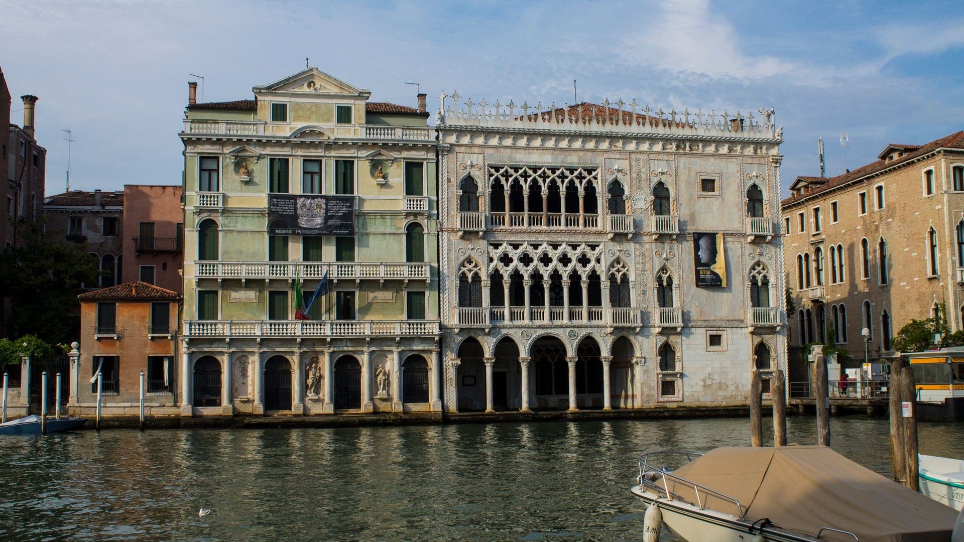 Historic Venetian buildings along the Grand Canal in Venice, Italy, featuring ornate architectural details and arched windows.
