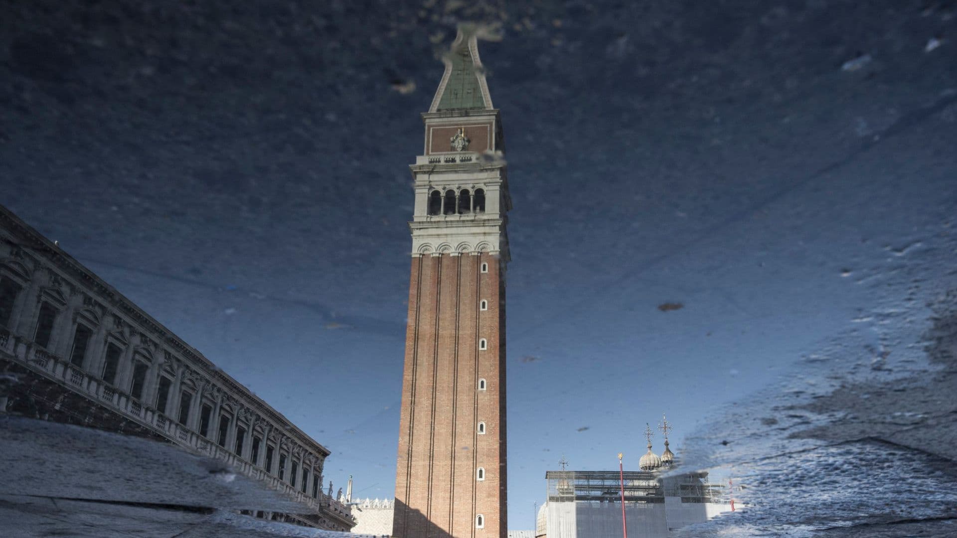Reflection of St. Mark's Campanile and buildings in a puddle in Venice, Italy.