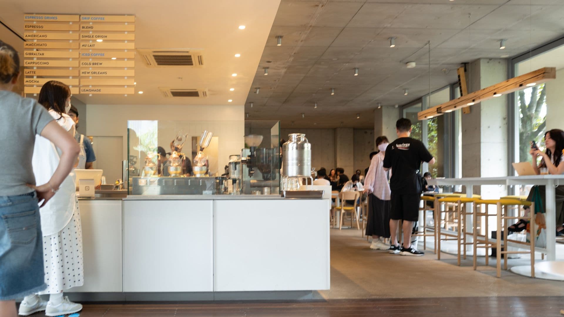 Baristas engaging with patrons at the minimalist Blue Bottle Coffee location in Aoyama.