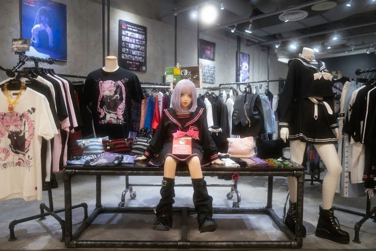 A clothing store with mannequins and racks displaying anime-themed clothing and accessories.